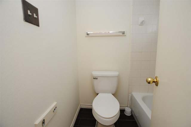 bathroom featuring a bathing tub, tile patterned flooring, and toilet