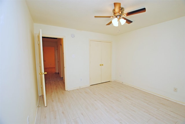 unfurnished bedroom featuring a closet, light hardwood / wood-style flooring, and ceiling fan