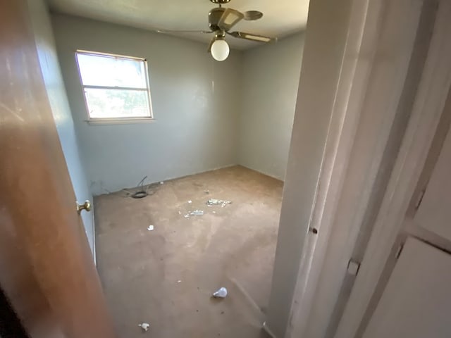 empty room with concrete floors and ceiling fan