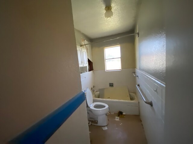 bathroom with a textured ceiling and toilet