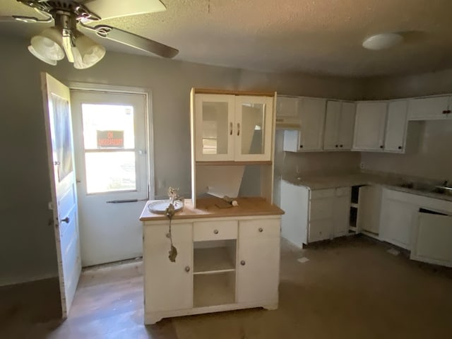 kitchen featuring white cabinets, ceiling fan, a textured ceiling, and kitchen peninsula