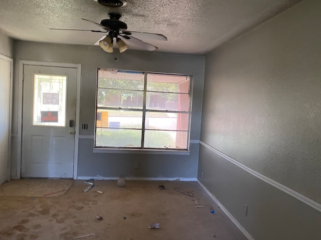 interior space featuring a healthy amount of sunlight, ceiling fan, and a textured ceiling