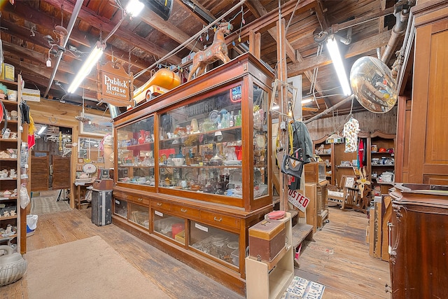 basement featuring wood walls and light hardwood / wood-style floors