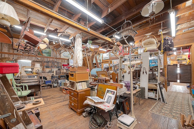 interior space with wood-type flooring, wooden walls, wooden ceiling, and lofted ceiling with beams