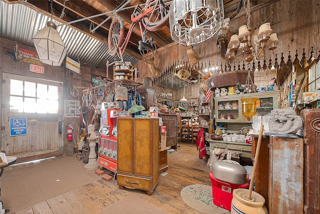 miscellaneous room with wood-type flooring and wooden walls