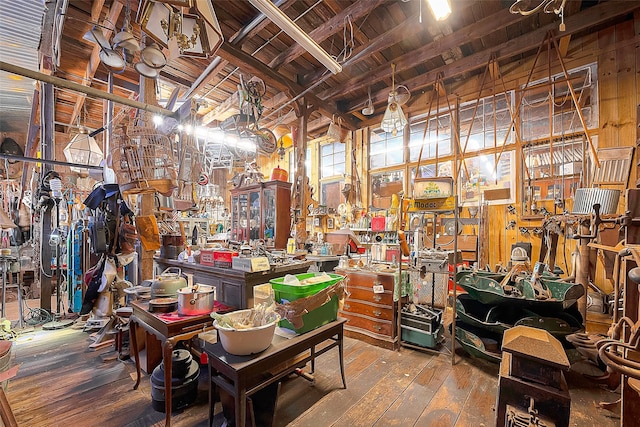 miscellaneous room with high vaulted ceiling, beamed ceiling, hardwood / wood-style floors, and wooden walls