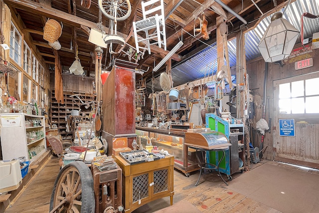 misc room with hardwood / wood-style flooring, wooden walls, and a workshop area