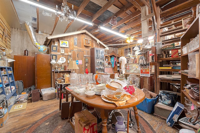 interior space with wood walls, wood-type flooring, and a chandelier