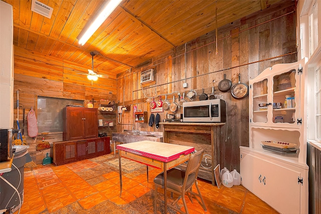 dining room with wood ceiling, wooden walls, and ceiling fan