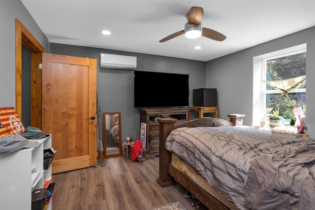 bedroom with hardwood / wood-style flooring, a wall unit AC, and ceiling fan