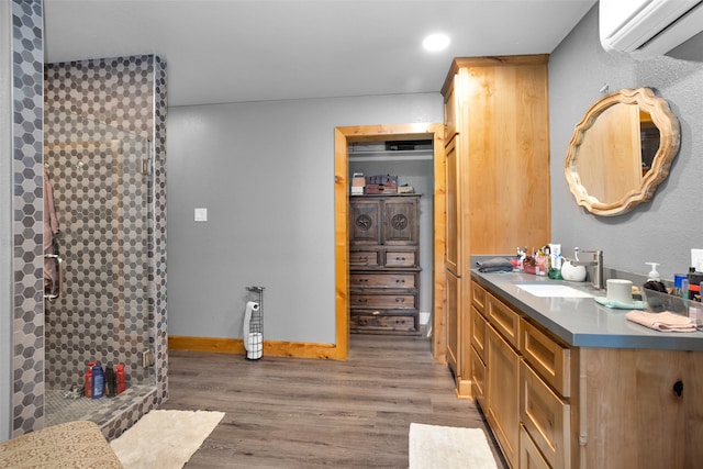 bathroom featuring a shower, vanity, hardwood / wood-style flooring, and an AC wall unit