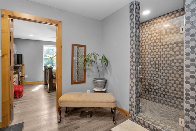 bathroom featuring a shower with shower door and hardwood / wood-style floors