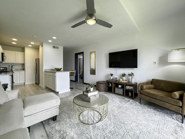 living room featuring light hardwood / wood-style floors and ceiling fan