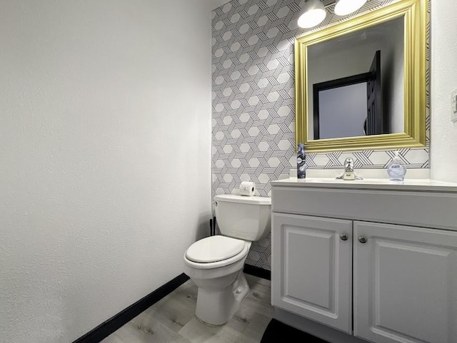 bathroom with wood-type flooring, vanity, and toilet