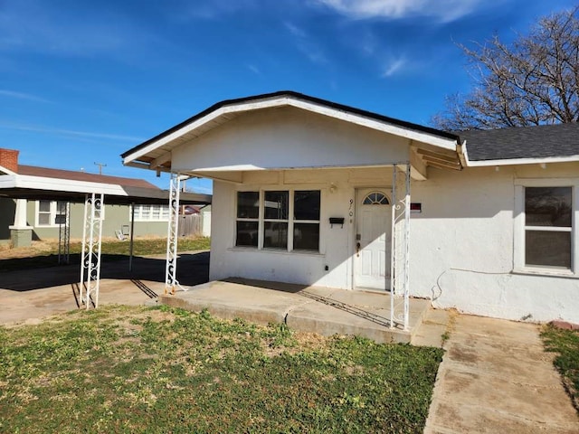 exterior space featuring a carport and a lawn