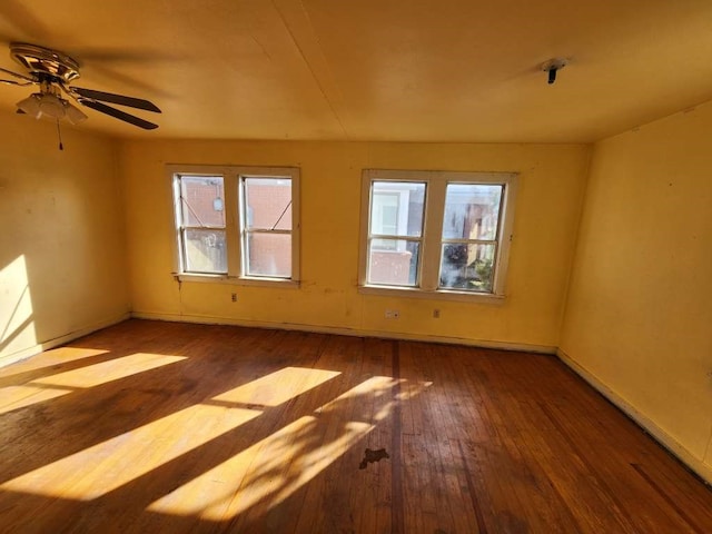 spare room with dark hardwood / wood-style floors and plenty of natural light