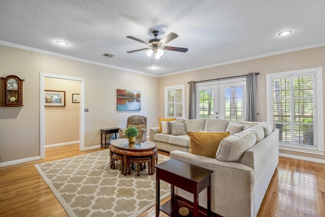 living room featuring crown molding, french doors, and light hardwood / wood-style floors