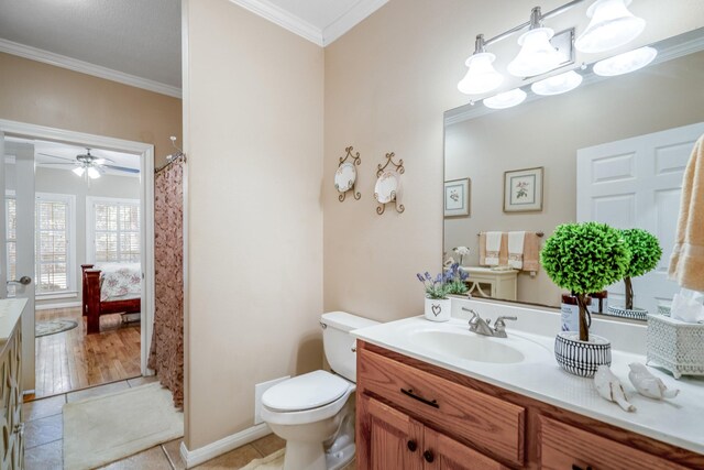 bathroom with tile patterned floors, ornamental molding, vanity, ceiling fan, and toilet