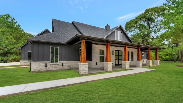 back of house featuring french doors and a lawn