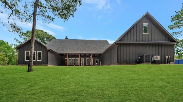 rear view of house with a yard and central air condition unit