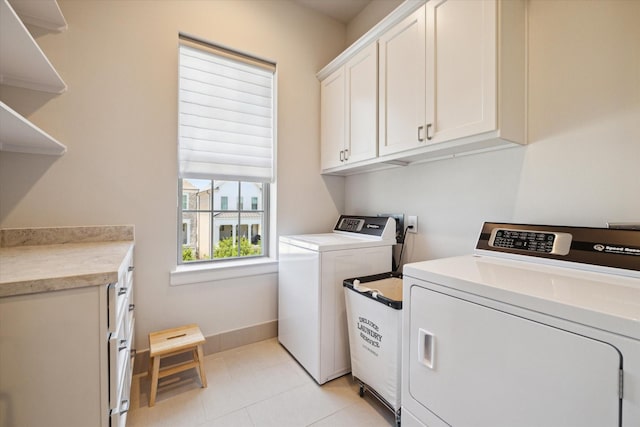 laundry area featuring washing machine and dryer and cabinets