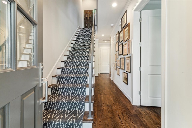 stairs with ornamental molding and hardwood / wood-style flooring