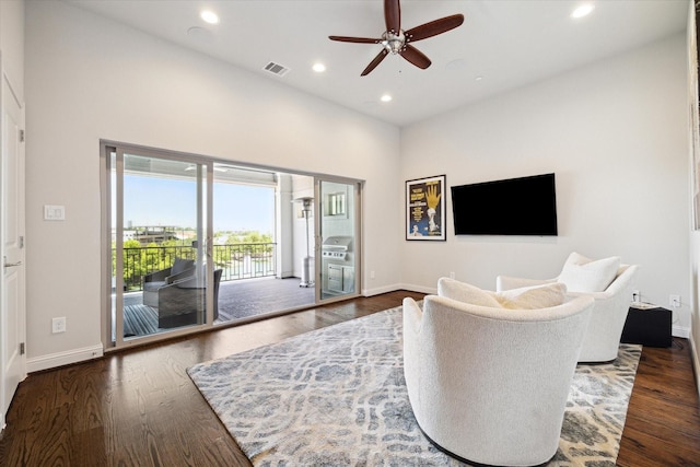 living room featuring ceiling fan and dark hardwood / wood-style floors