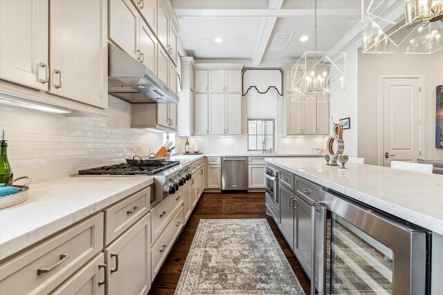 kitchen featuring stainless steel appliances, wine cooler, light stone counters, and decorative light fixtures