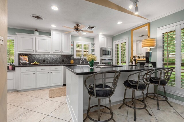 kitchen with ceiling fan, stainless steel appliances, white cabinets, and backsplash