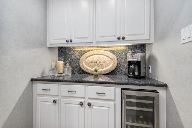 bar with beverage cooler, white cabinets, and backsplash