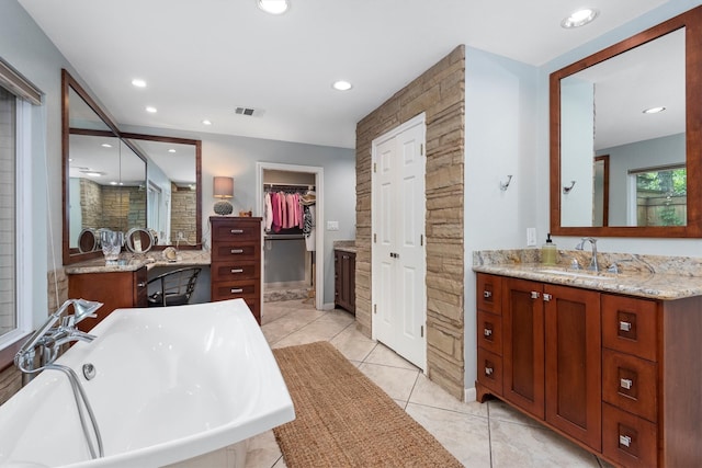 bathroom featuring double sink vanity, tile floors, and a bathtub