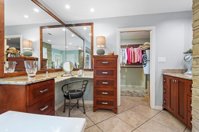 bathroom featuring tile flooring, a bathing tub, and vanity