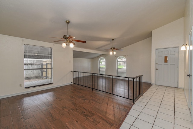 empty room with ceiling fan, light hardwood / wood-style flooring, and lofted ceiling