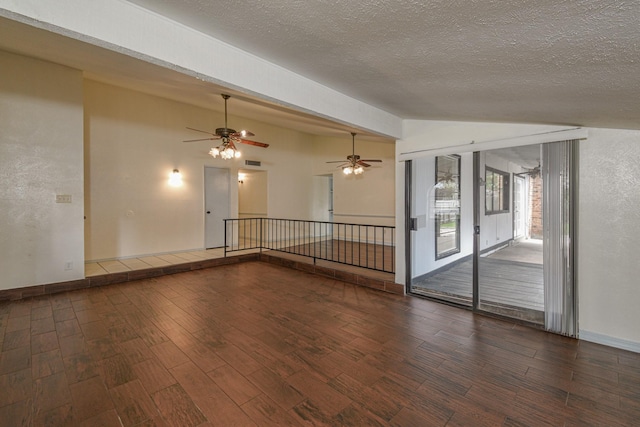 spare room with lofted ceiling, dark hardwood / wood-style flooring, ceiling fan, and a textured ceiling