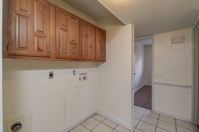 washroom featuring washer hookup, electric dryer hookup, cabinets, and light tile patterned floors