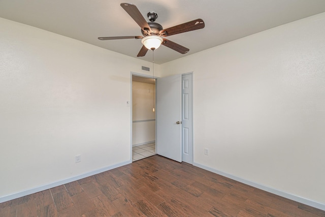 unfurnished room with dark hardwood / wood-style floors and ceiling fan