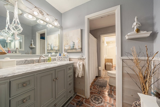 bathroom with tile floors, toilet, and vanity with extensive cabinet space