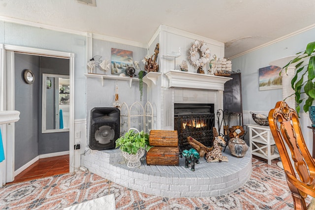 living room with a brick fireplace, hardwood / wood-style floors, and ornamental molding