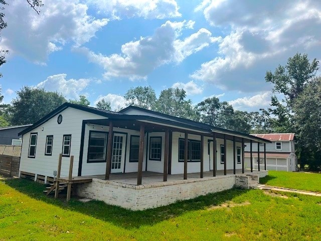 rear view of house featuring a lawn and a garage