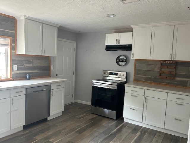 kitchen featuring appliances with stainless steel finishes, white cabinetry, a textured ceiling, and dark wood-type flooring