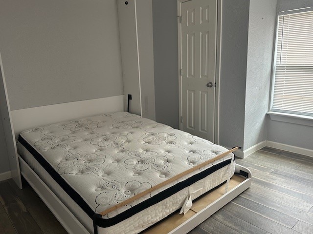 bedroom featuring multiple windows and hardwood / wood-style floors