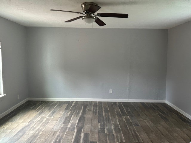 empty room with dark hardwood / wood-style floors and ceiling fan