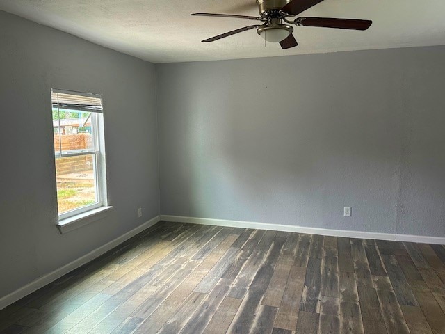 empty room with dark hardwood / wood-style floors and ceiling fan