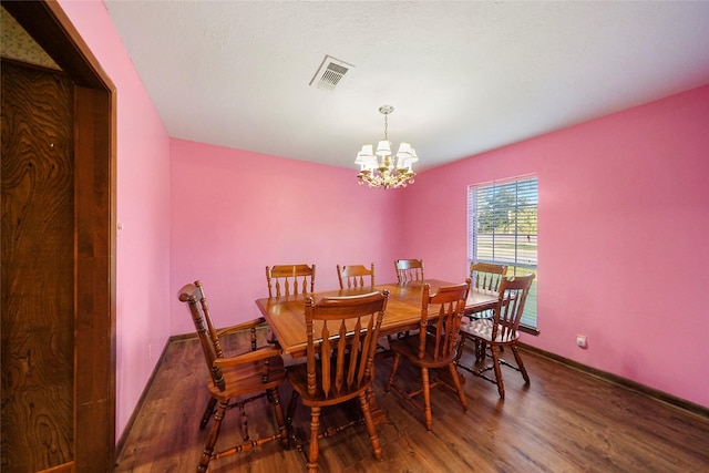 dining room with dark hardwood / wood-style flooring and a notable chandelier