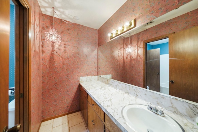 bathroom with tile patterned flooring, vanity, and a chandelier