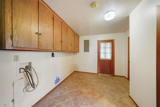 clothes washing area featuring light tile patterned floors, electric panel, cabinets, washer hookup, and a textured ceiling