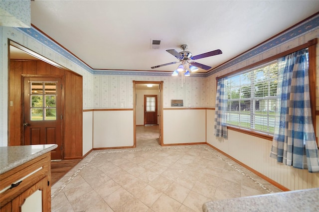 unfurnished room featuring crown molding, a healthy amount of sunlight, and ceiling fan