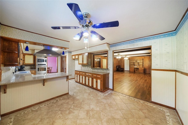 kitchen featuring sink, a breakfast bar, appliances with stainless steel finishes, ventilation hood, and kitchen peninsula