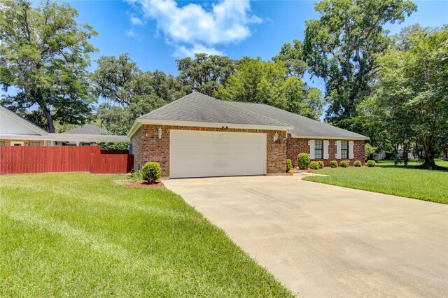 single story home featuring a garage and a front yard