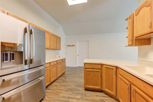 kitchen with crown molding, vaulted ceiling, stainless steel fridge with ice dispenser, kitchen peninsula, and light hardwood / wood-style floors